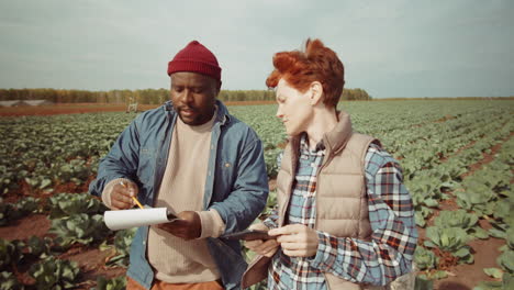 Multiethnic-Coworkers-Discussing-Plans-on-Farm-Field
